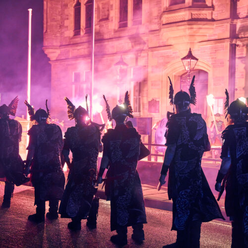 People dressed as Vikings at night holding fire torches