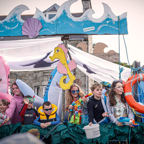 People on a float during a parade with a sea theme