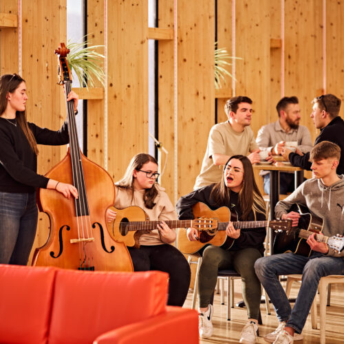 Young people play in a band in a cafe setting