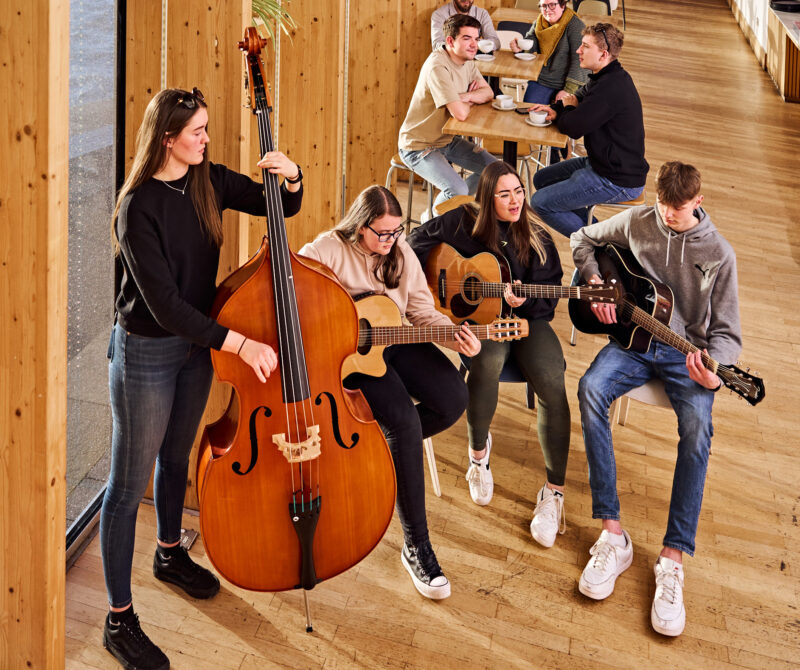 Young people play in a band in a cafe setting