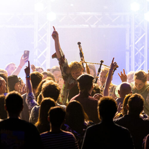 A crowd and a piper at a live event