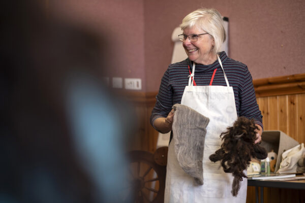 A woman smiling holding wool