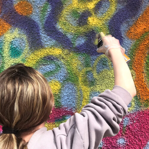 A person spray painting a wall