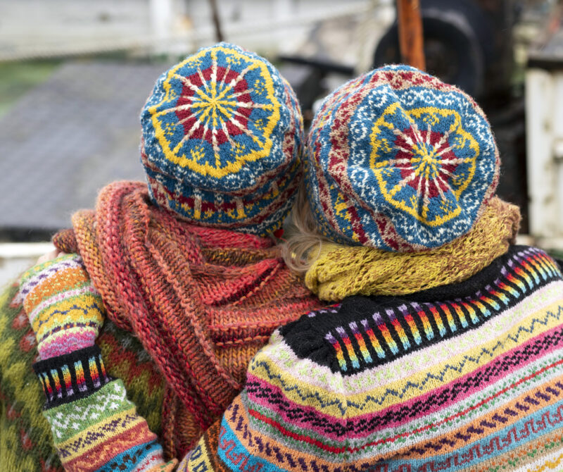Two people with knitted hats, jumpers, scarves and gloves