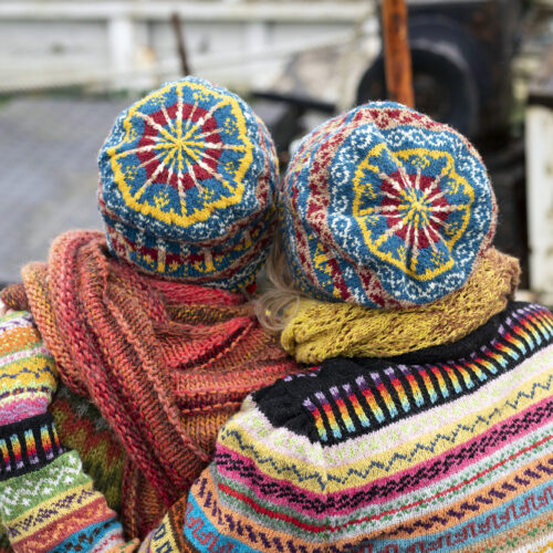 Two people with knitted jumpers, hats scarves and gloves